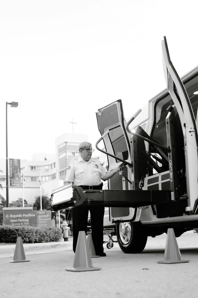 Black and white photo of a man operating a vehicle lift, showcasing accessibility.